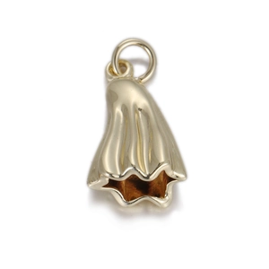 Close-up of polished gold skull pendant with flowing artistic lines and jumping ring