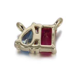 Vue macro d'un pendentif en or avec zircon bleu et pierre précieuse rouge rectangulaire