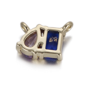 Détail d'un pendentif géométrique doré avec zircon violet poire et bleu rectangulaire