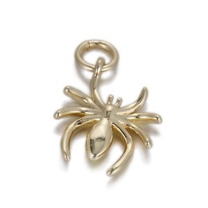 Detailed macro view of a golden spider pendant showing polished alloy finish and DIY loop