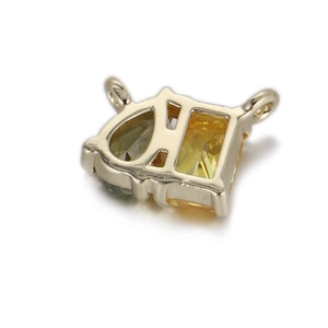 Détail macro d'un pendentif en cuivre avec zircons jaunes tailles poire et émeraude