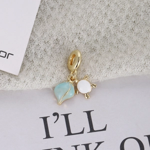 Macro shot of gold-plated starfish and turtle charm with light blue enamel finish