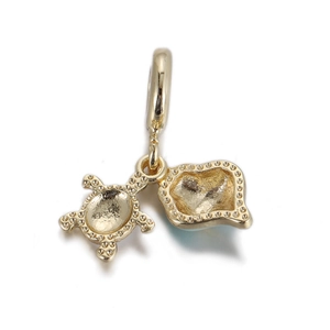 Detail of gold turtle pendant featuring textured sandy finish and polished dotted edges
