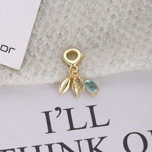 Golden ocean charm featuring a blue gemstone sea turtle and starfish with leaf pendant