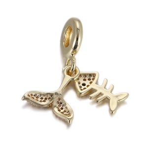 Detail of golden fishbone and whale tail charms with shimmering micro-set zircons