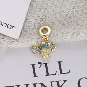 Detail of ocean-themed gold charms with blue enamel jellyfish, crab and seashell