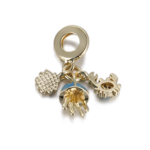 Detail of gold charms with blue enamel jellyfish, crab, and pavé crystal floral cluster