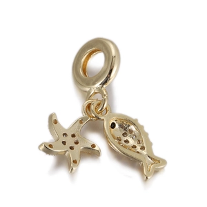 Macro shot of gold ocean theme charms featuring a starfish and hollow fish pendant