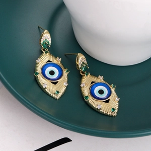 Detailed view of evil eye stud earrings with blue center and colorful crystals on a ceramic tray