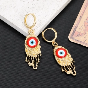 Detailed view of evil eye earrings with golden melting texture and colorful enamel