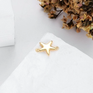 Makroaufnahme von Seestern-Schmuckverbinder in Gold mit zwei Ösen auf weißem Stein