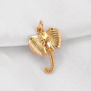 Detailed close-up of a golden elephant pendant with cubic zirconia on white silk