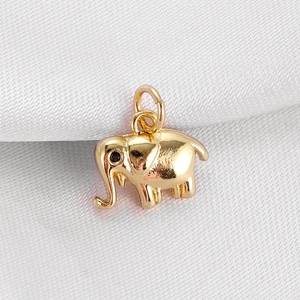 Macro view of a golden elephant pendant with a black gemstone eye for DIY jewelry making