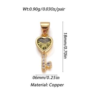 Macro detail of a 18mm gold key pendant with green heart stone and white zircon stones