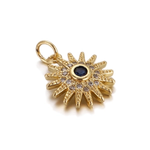 Dettaglio del ciondolo a sole dorato con pietra blu scuro e zirconi brillanti