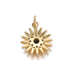 Dettaglio pendente a sole dorato con pietra centrale blu scuro e inserti in zircone