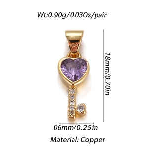 Detailed view of heart-shaped key pendant in gold finish with purple stone and small diamonds