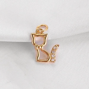 Detail of rose gold cat pendant with cubic zirconia tail on white silk fabric background