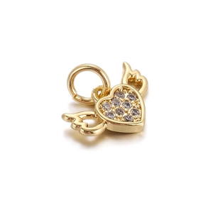Detailed close-up of golden heart wing pendant with sparkling pavé-set crystals
