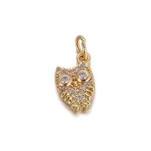 Macro shot of owl charm pendant in gold finish with white cubic zirconia stones