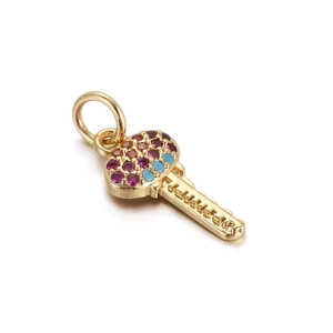 Detailed macro view of gold heart-shaped key pendant with colorful zircon stones