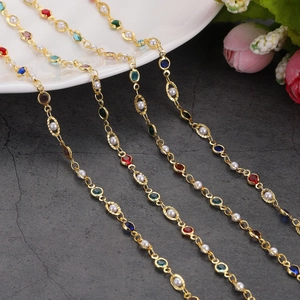 Detail of 14K gold-plated necklaces with colorful gemstones and pearls on a stone background