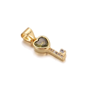 Detail of a gold heart key pendant with green stone and sparkling zircon accents