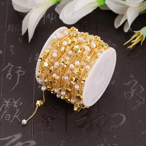Handmade stainless steel jewelry chain with pearls and stars on a white plastic spool