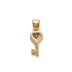 Detailed view of a gold heart key pendant featuring a sparkling purple gemstone