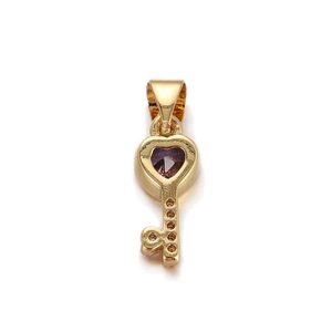 Detail of a gold-plated heart key pendant with a vibrant purple heart-shaped zircon stone