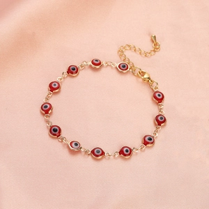 Detail of red evil eye bracelet featuring gold-plated chain and adjustable lobster clasp