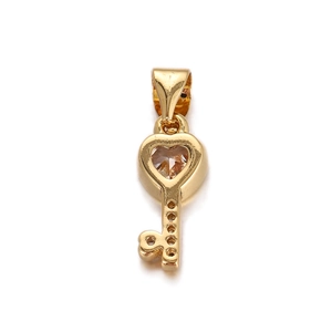 Detail of a golden heart key pendant with clear gemstone and delicate hollow design