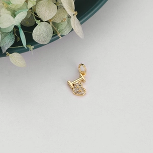 Macro shot of gold heart pendant with letter I and glittering pave zirconia stones