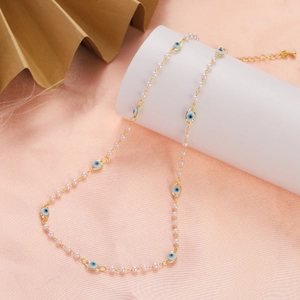 Detail showing Evil Eye pearl necklace with gold chain and blue enamel pendants