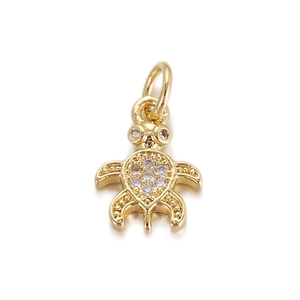 Macro view of a gold turtle pendant with shimmering zircon pavé and hanging ring