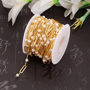 DIY gold paperclip chain with white pearls on a spool for handmade bridal jewelry making