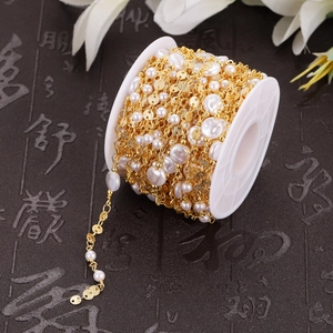 Baroque pearls and gold plated stainless steel chain wound on a white spool roll