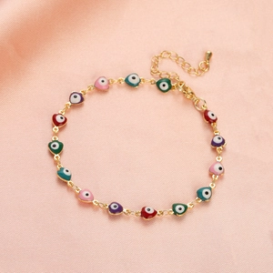 Detail of colorful enamel heart evil eye pendants on a gold plated stainless steel bracelet