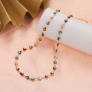 Detailed view of colorful heart-shaped evil eye enamel pendants on a gold chain necklace