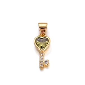 Detail of a gold heart-shaped key pendant with green gemstone and white zircon stones