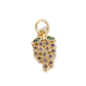 Macro detail of a gold grape charm with vibrant purple zircons and green leaf stones