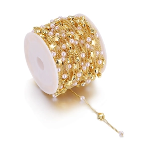 Golden DIY jewelry chain with pink faux pearls and metallic stars on white plastic spool
