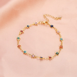 Macro detail of gold star charms with colorful enamel evil eye inlay on adjustable chain