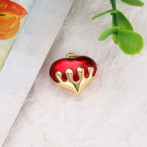 Macro view of heart-shaped dark red translucent pendant with gold plated melting metal detail