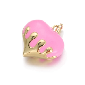 Detailed view of heart charm with pink enamel inlay and gold fluid metal drip effect