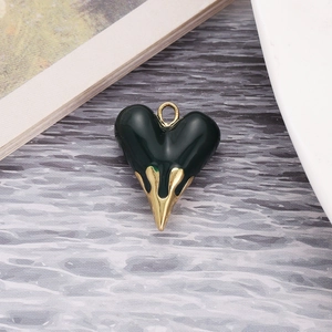 Detailed view of dark green lava heart pendant with gold trident-style accents