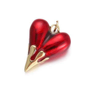 Macro shot of a red enamel heart pendant with golden lava-style metal casing details