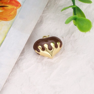 Close-up of gold-plated heart pendant with brown enamel drip oil for DIY jewelry