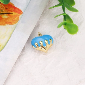 Detailed close-up of heart-shaped gold-plated charm with blue melting enamel detail