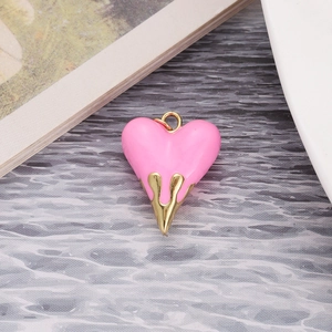 Detailed macro view of heart pendant with pink enamel and liquid gold dripping effect